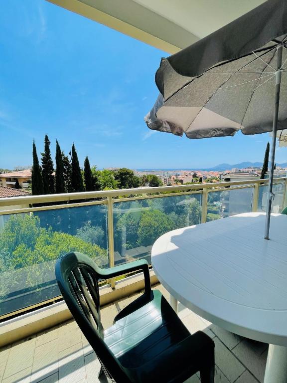d'une table blanche et d'un parasol sur le balcon. dans l'établissement Floriana, à Cannes