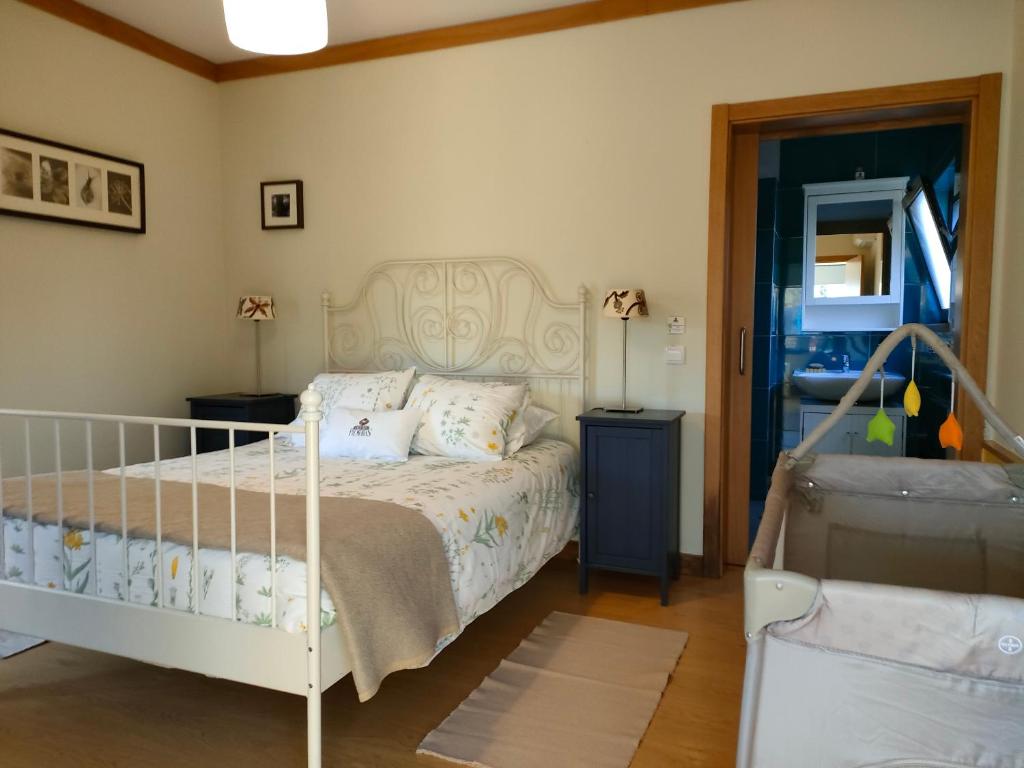 a bedroom with a bed with a white bed frame at Casa Das Palmeiras-Pedagogic Farm in Mangualde