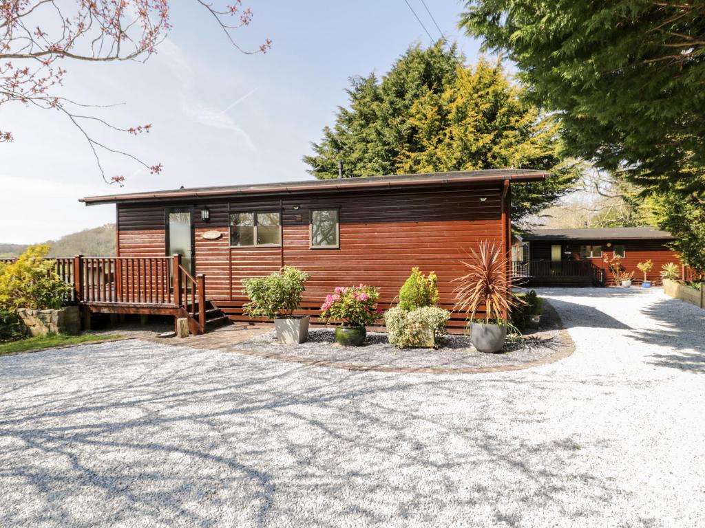 a log cabin with a porch and some plants at Summertime Lodge in Abergele