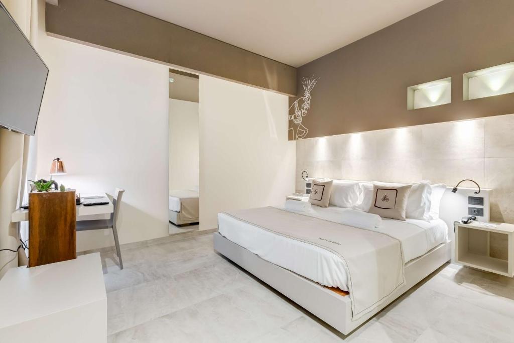 Schlafzimmer mit einem großen weißen Bett und einem Schreibtisch in der Unterkunft Best Western Plus Hotel Terre di Eolo in Patti