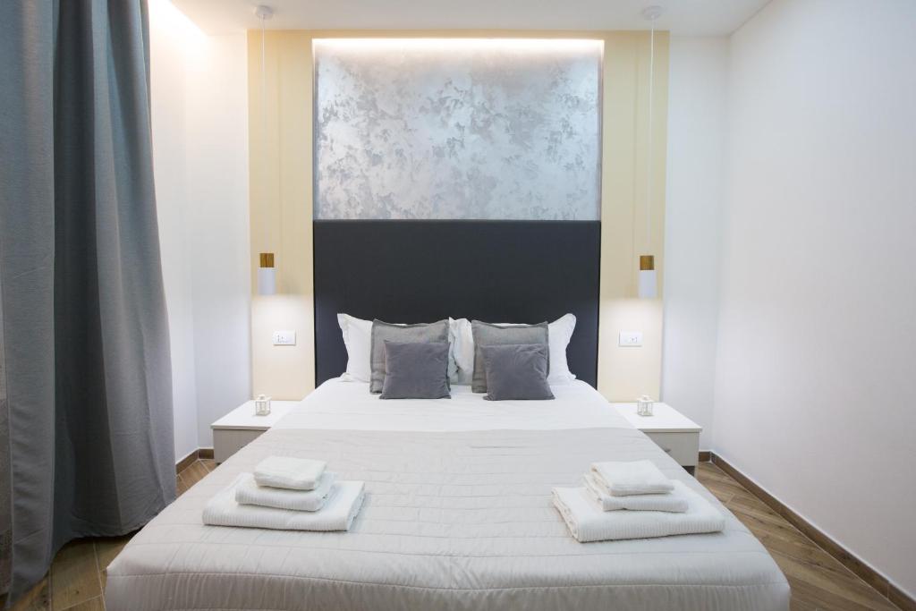 1 dormitorio con 1 cama blanca y 2 toallas en Sweet Night en La Spezia