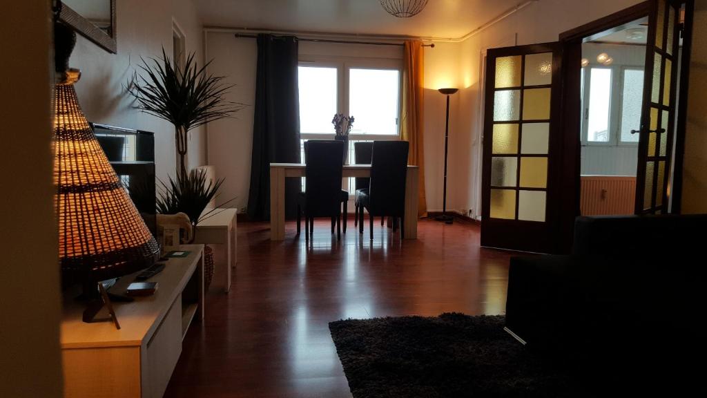 a living room with a table and chairs and a window at Près de Melun, Appt 3 pièces 2 chambres tout confort in Dammarie-lès-Lys