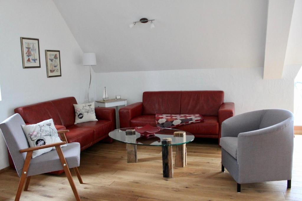 a living room with a red couch and a table at Fehmarn-OstseeferienRehwiese 1531 in Sahrensdorf