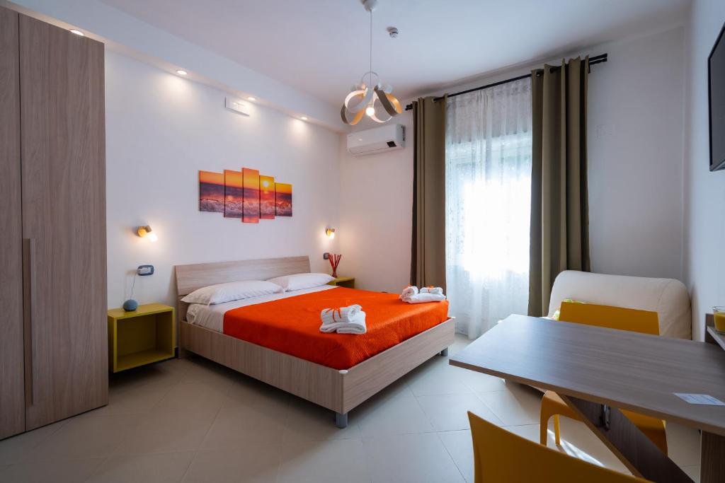 een slaapkamer met een bed, een tafel en een bureau bij SunSea Bed And Breakfast in Agropoli