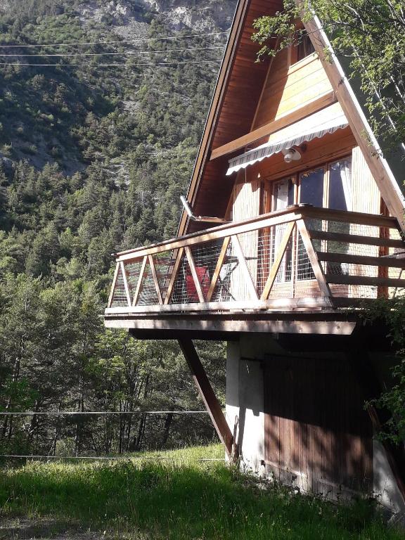 une maison avec un balcon sur le côté dans l'établissement chalets montagnard, à Jausiers
