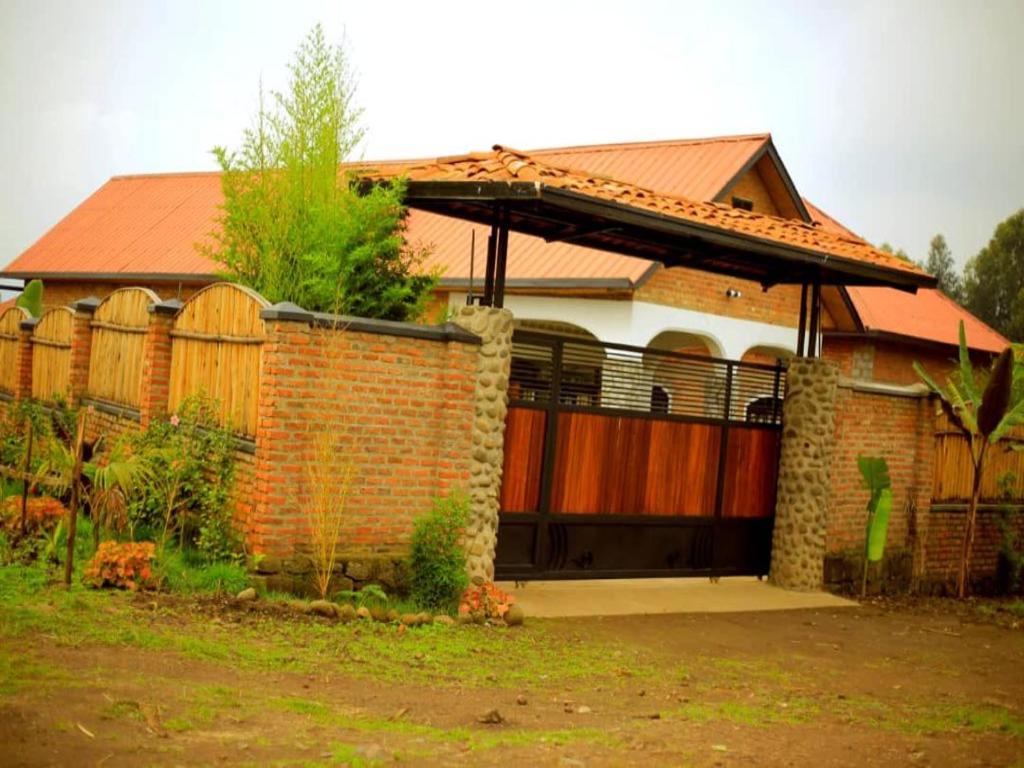 a brick house with a gate and a fence at URUGANO VIRUNGA PALACE in Nyarugina