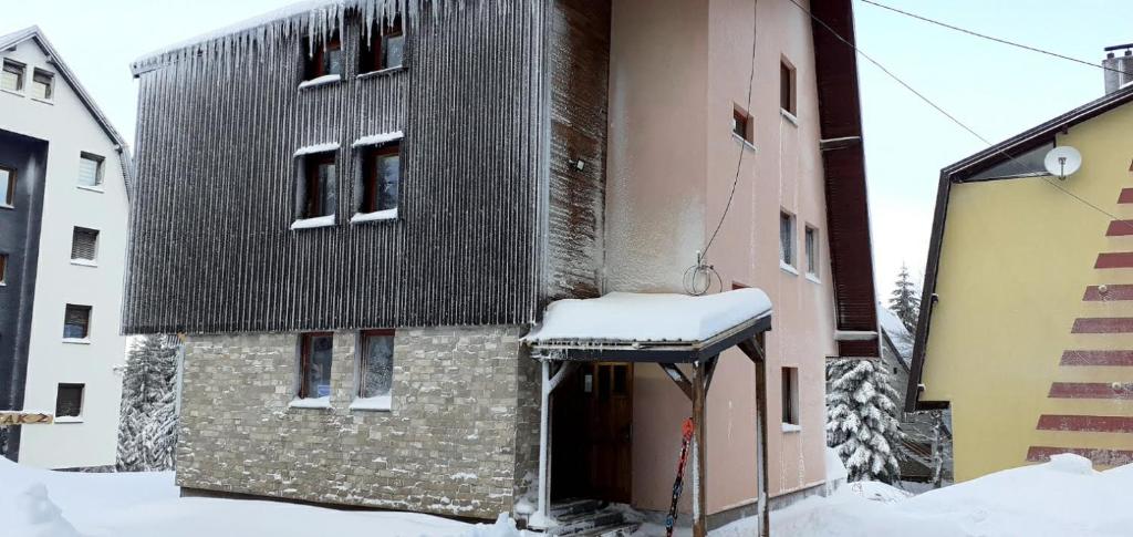 a building with snow on top of it at Apartments Gaga in Jahorina