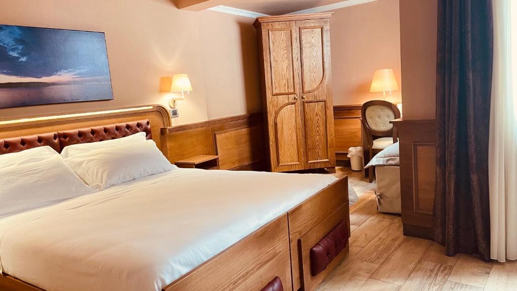 Schlafzimmer mit einem großen Bett mit einem Kopfteil aus Holz in der Unterkunft Le Club Boutique Hotel in Lecce