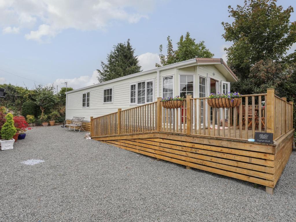 a mobile home with a deck and a fence at Tegfryn Bach in Beaumaris