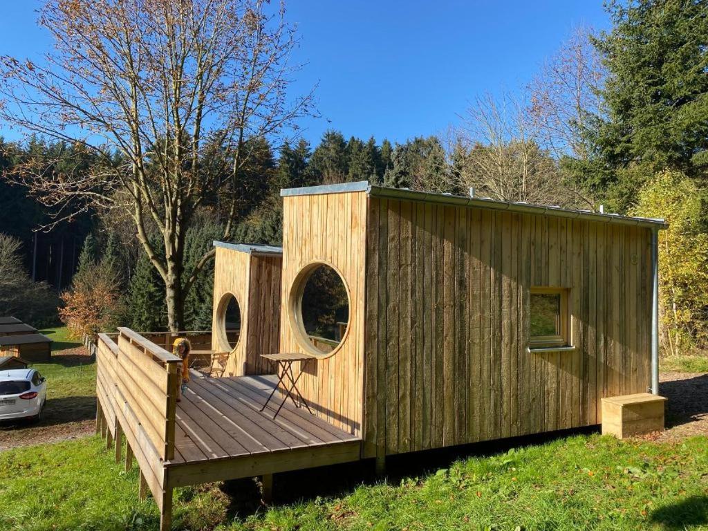 una pequeña casa de madera con terraza de madera en Zinipi Retreat Gelenau "Eule" en Gelenau