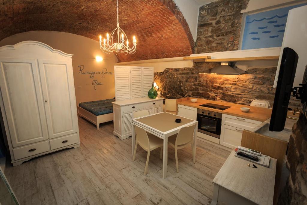 una cocina con armarios blancos y una mesa. en Rifugio dei Pescatori, en Riomaggiore