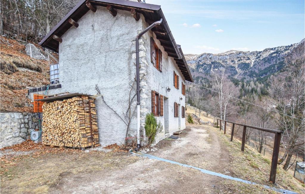 a building on a dirt road next to a mountain at Casa Delleremita in Sovramonte
