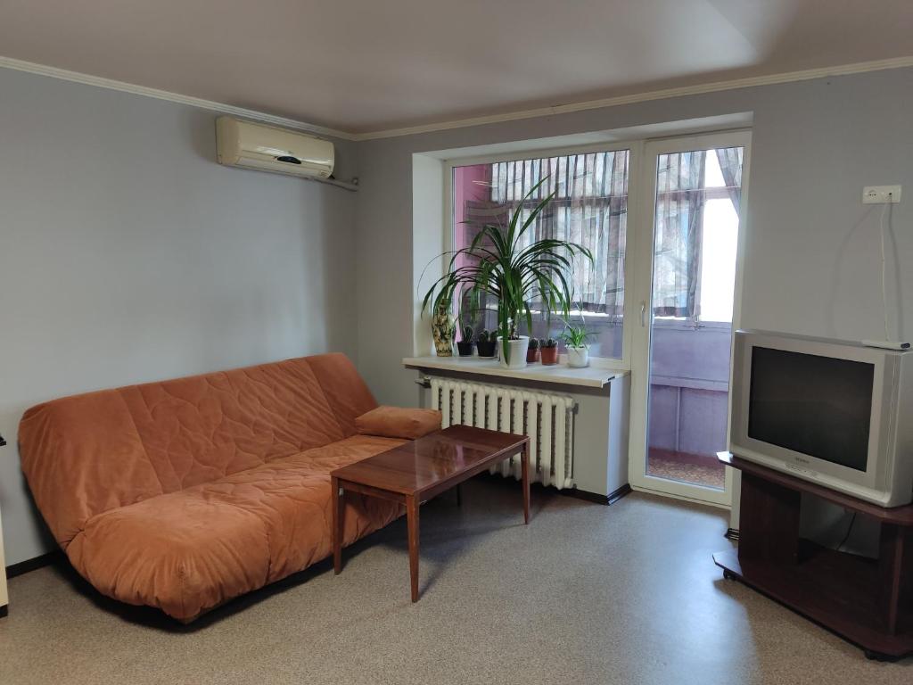 ein Wohnzimmer mit einem Sofa und einem TV in der Unterkunft проспект Миру 35 in Krywyj Rih