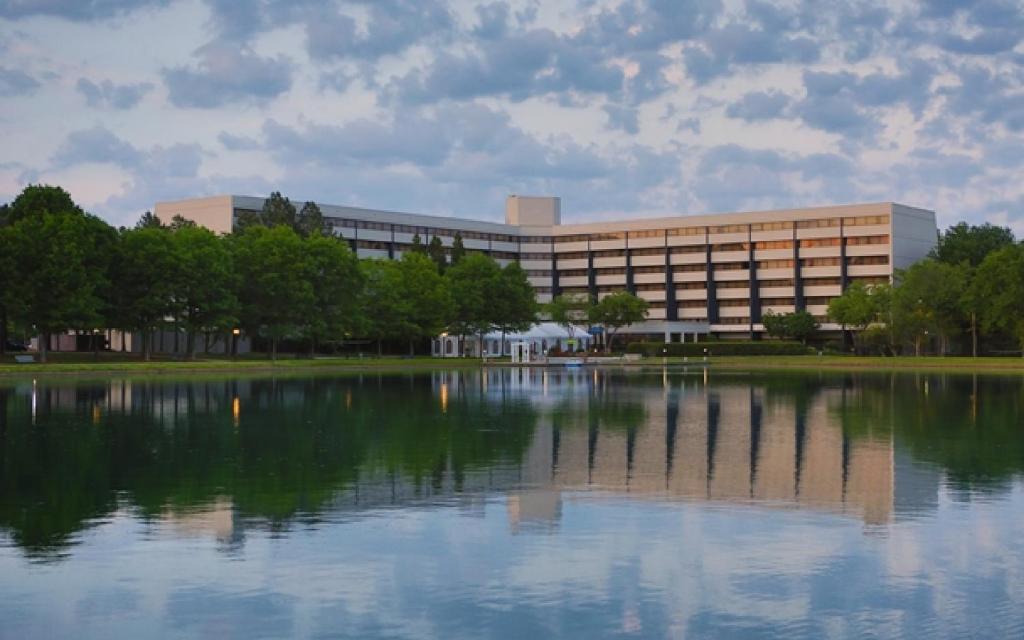 a building with a lake in front of it at DoubleTree Suites by Hilton Raleigh-Durham in Durham