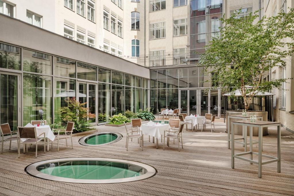a courtyard with tables and chairs and a building at Mövenpick Hotel Berlin Am Potsdamer Platz in Berlin