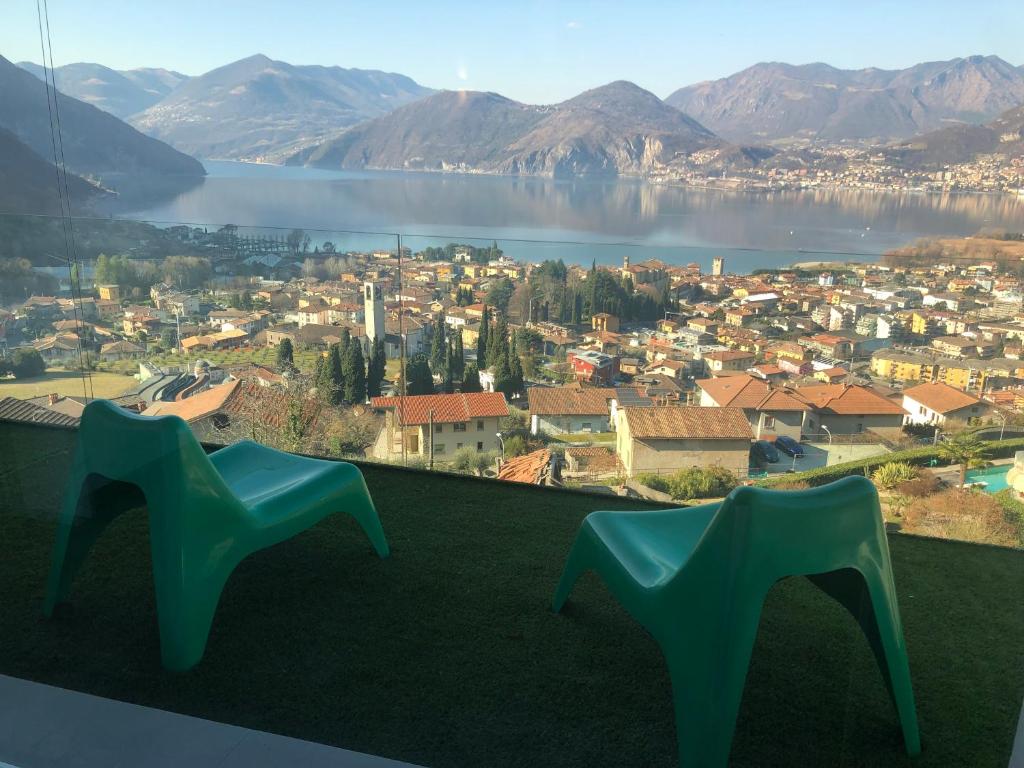 2 chaises bleues assises au sommet d'une colline surplombant une ville dans l'établissement Il Cubo di Anja, à Pisogne