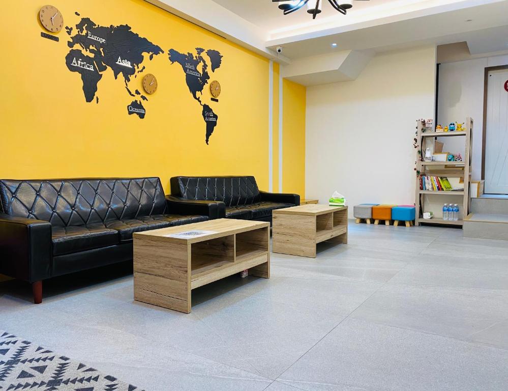 a living room with a couch and a world map on the wall at Ji Apartment in Tainan