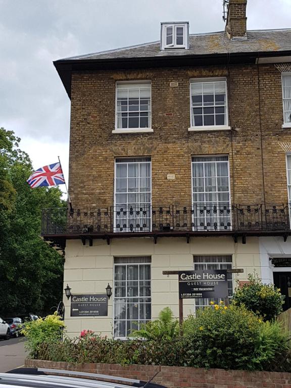 a large brick building with a balcony and a british flag at Castle House Guest House in Dover