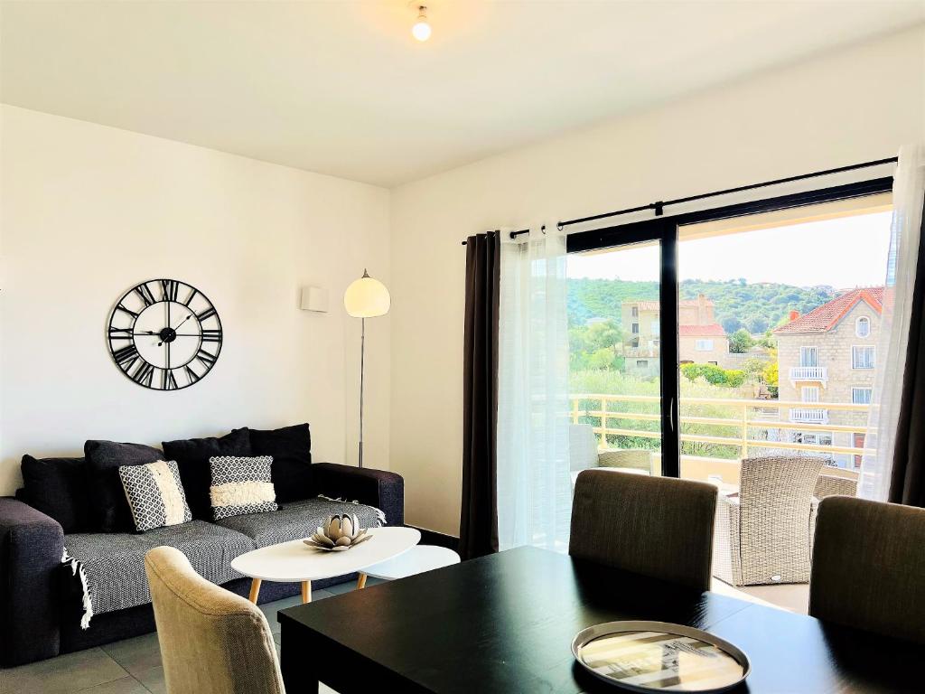 un salon avec un canapé et une table dans l'établissement Jardins de Quatrina centre ville, à Propriano