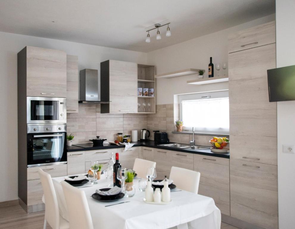 a kitchen with a white table and white chairs at Villa Orchidea in Valledoria