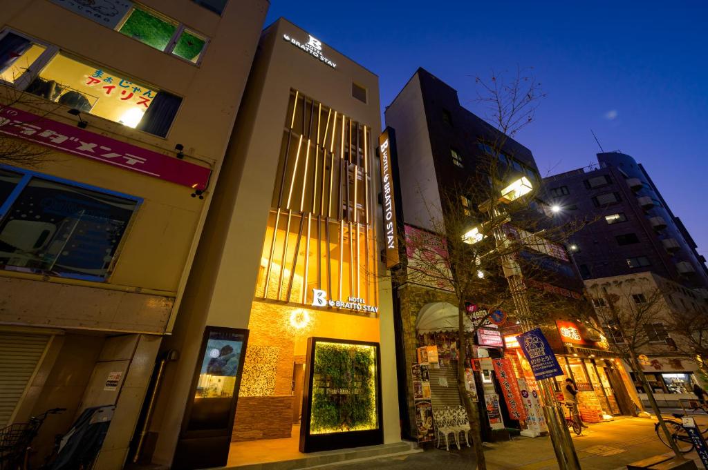 a building on a city street at night at hotel brattostay ホテル ブラットステイ in Hachioji