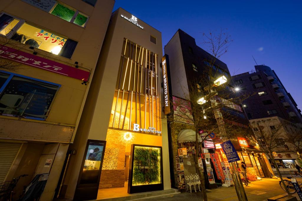 ein Gebäude in einer Stadtstraße in der Nacht in der Unterkunft hotel brattostay ホテル ブラットステイ in Hachioji