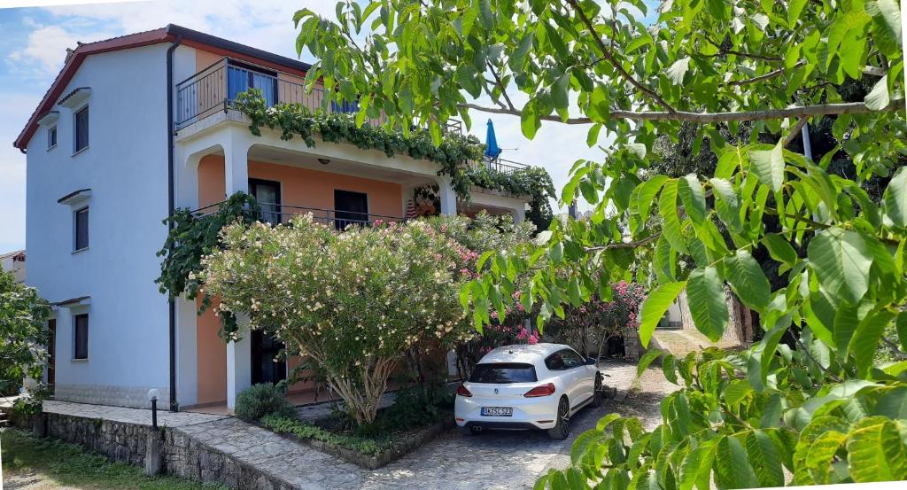 a white car parked in front of a house at Apartments Coki in Funtana