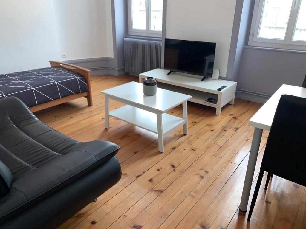 een woonkamer met een bank en een salontafel bij Appartement de la République in La Tour-du-Pin