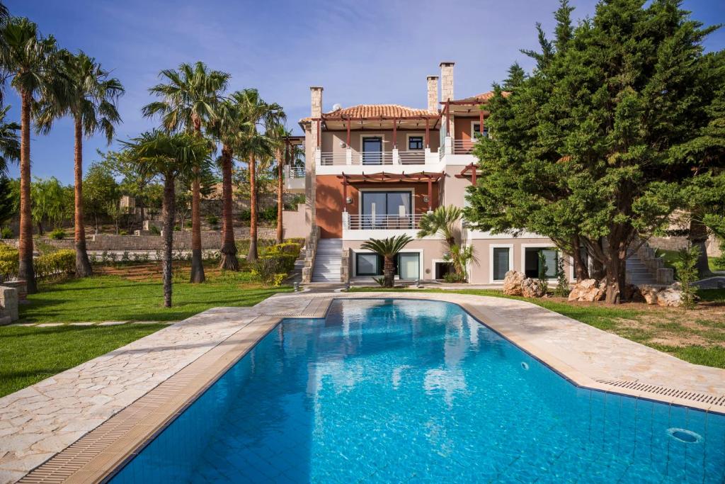 uma casa com piscina em frente a uma casa em Villa Kissos by PosarelliVillas em Kipárissos