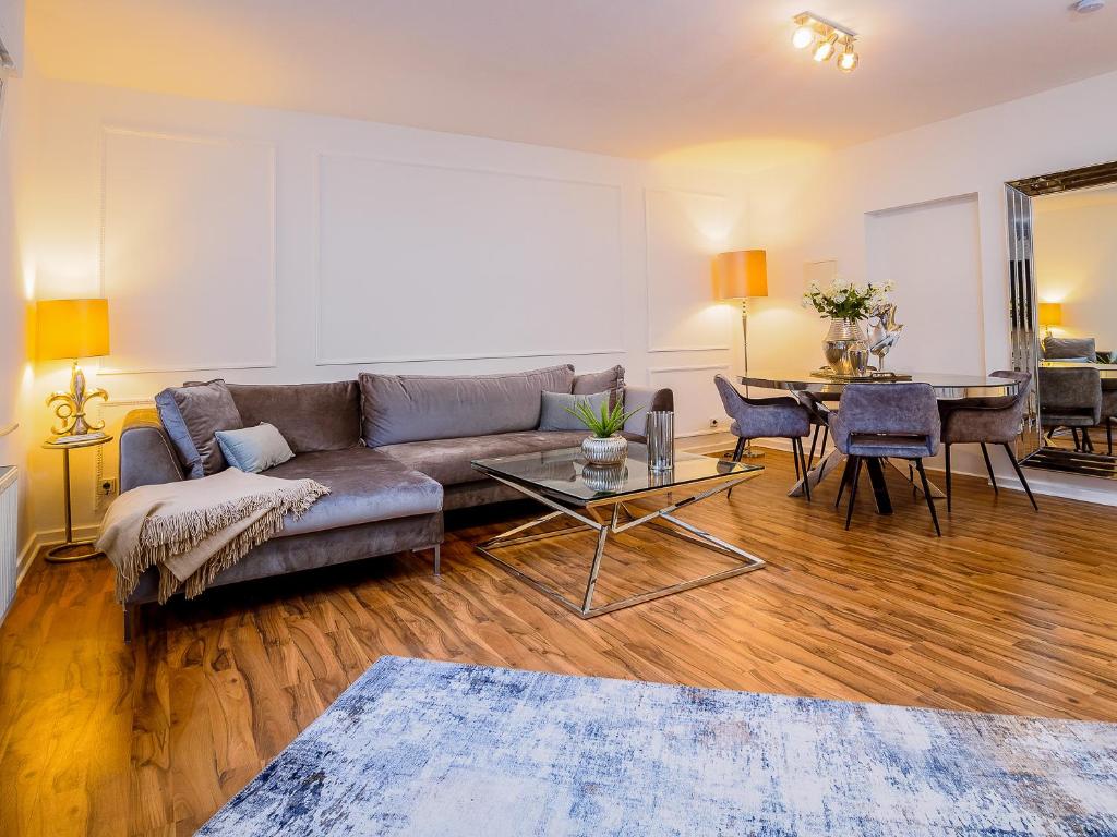 - un salon avec un canapé et une table dans l'établissement Exklusive und gemütliche Unterkünfte in Krefeld - JUNIK Apartments, à Krefeld