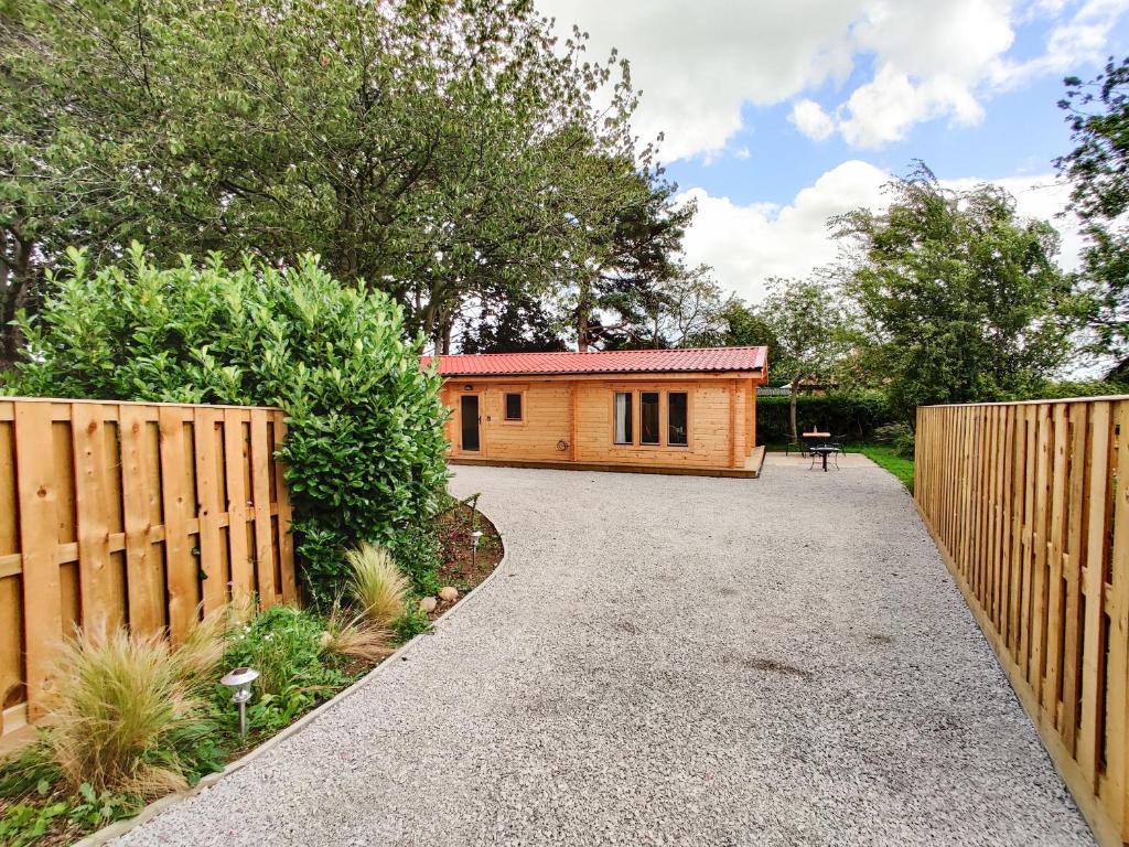 a home with a wooden fence and a house at Gardener's Lodge in York