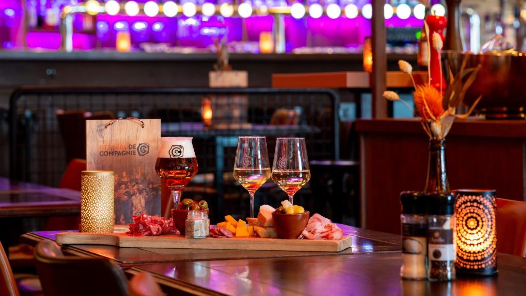 Herberg de Compagnie في إنكهاوزن: كأسين من النبيذ يجلسون على طاولة في مطعم