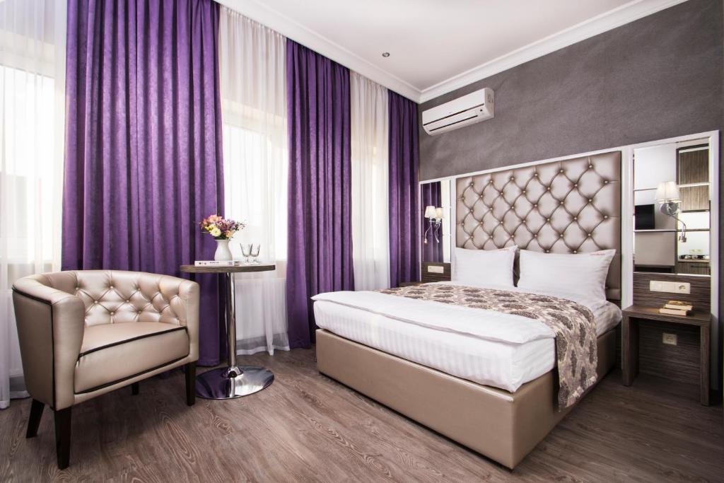 una camera d'albergo con letto e sedia di BonApart Hotel by UHM a Kiev