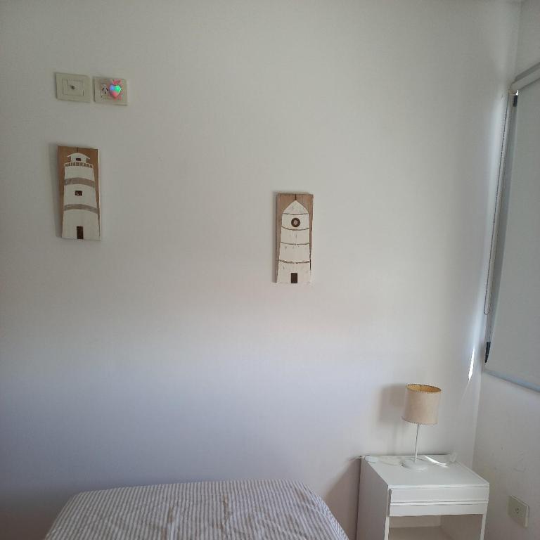 a bedroom with a white wall with two robots on the wall at SuMar in Puerto Madryn