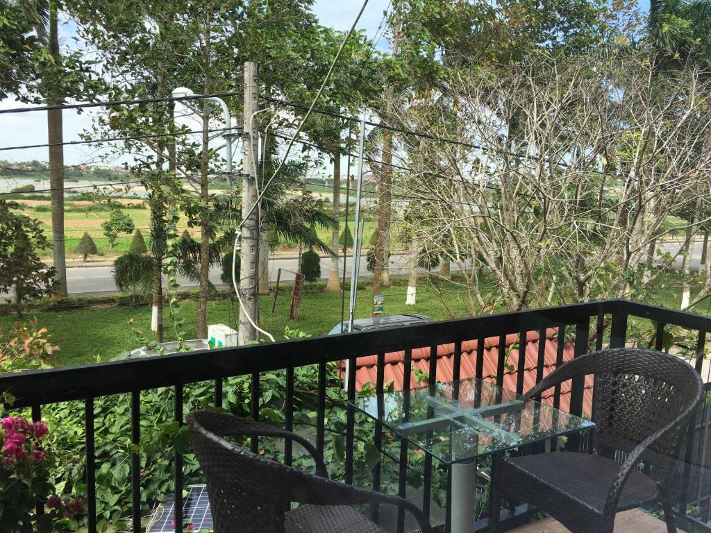 a table and chairs on a balcony with a view at Hana Riverside Villa in Quảng Ngãi
