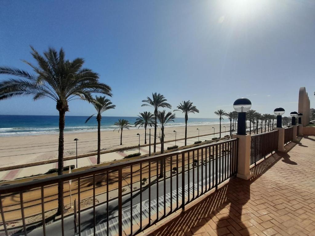een uitzicht op een strand met palmbomen en de oceaan bij Costa Blanca Holiday Rental AltaMar I in El Campello