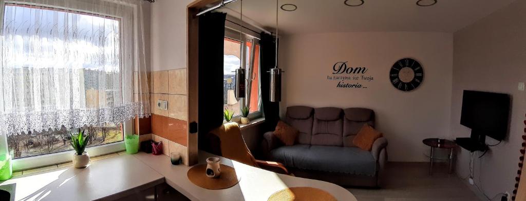 ein Wohnzimmer mit einem Sofa und einem Fenster in der Unterkunft Apartament Hetmańska in Wałbrzych