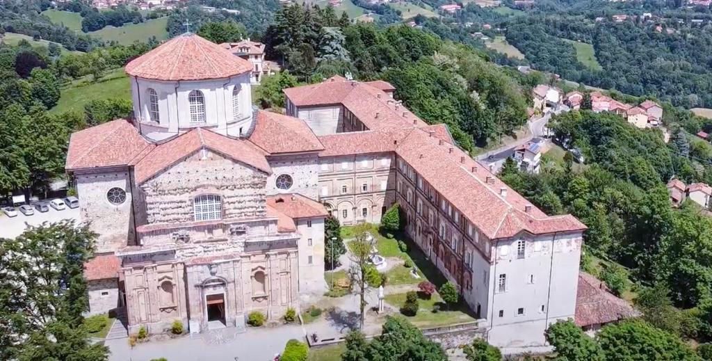 um edifício antigo com uma torre no topo de uma colina em Santuario di Graglia Resort em Graglia