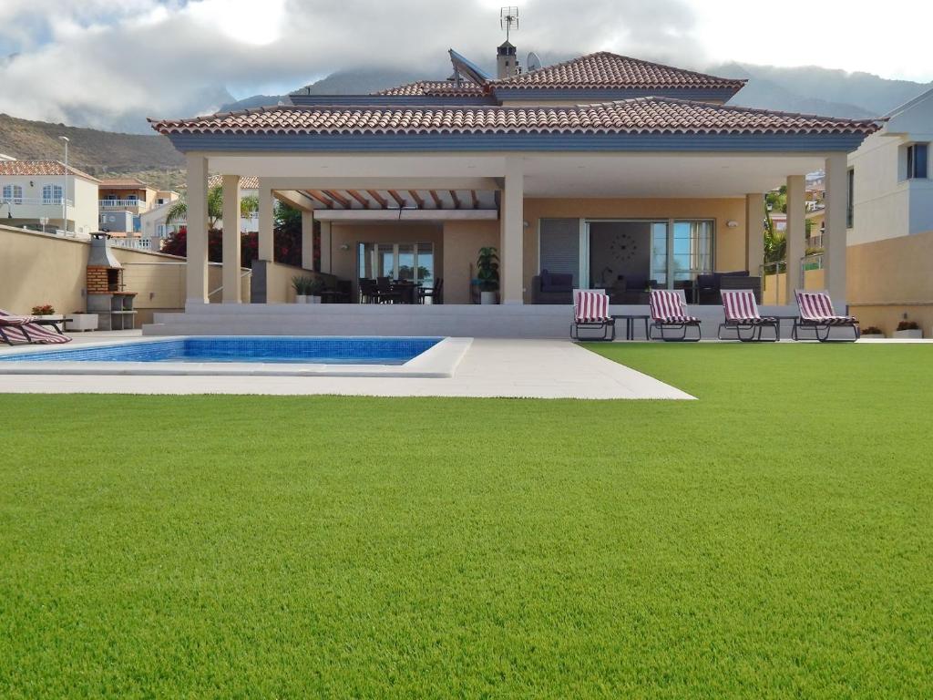 a house with a lawn and a swimming pool at 5 bedrooms Villa Costa Adeje in Adeje