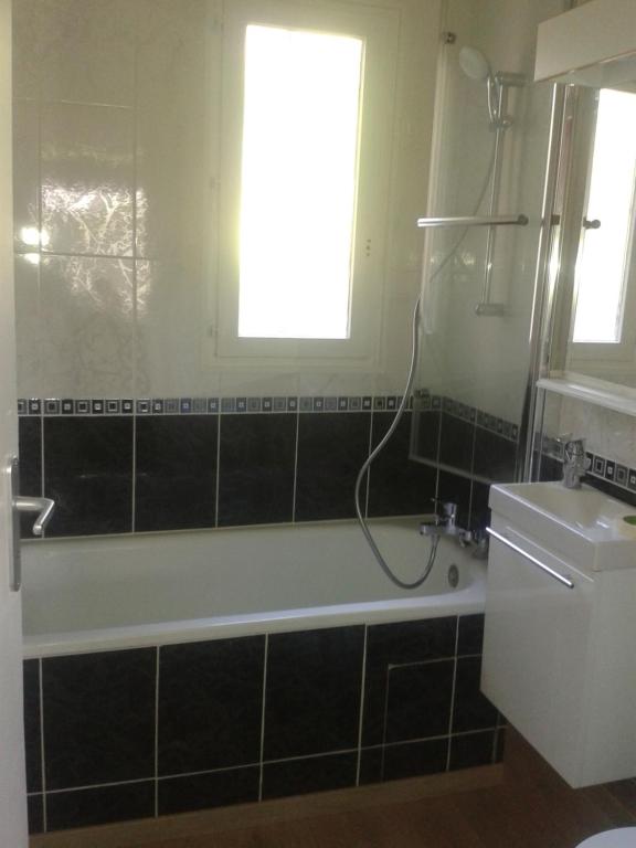 une salle de bain avec baignoire et toilettes et une fenêtre dans l'établissement Au Clair Vallon, à Houlgate