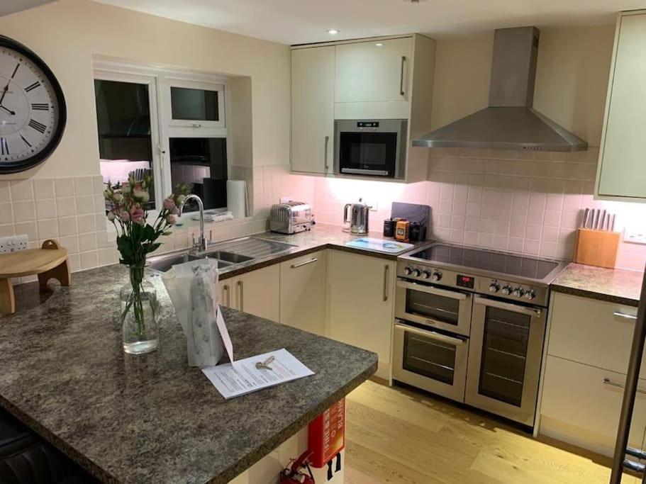 a kitchen with a counter and a clock on the wall at 44 Raleigh Close@Padstow in Padstow