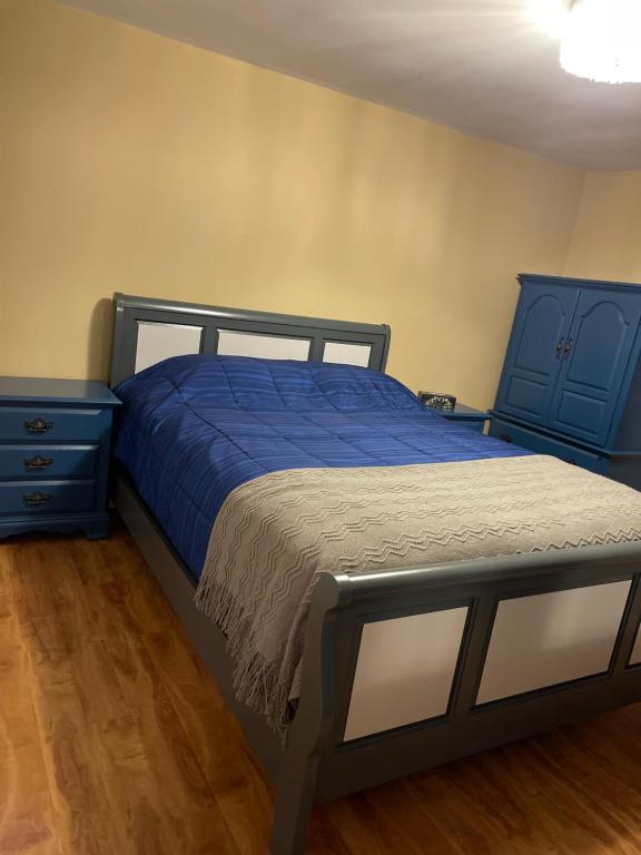 a bedroom with a blue bed and a blue dresser at Lemon Tree Inn in Fort McMurray