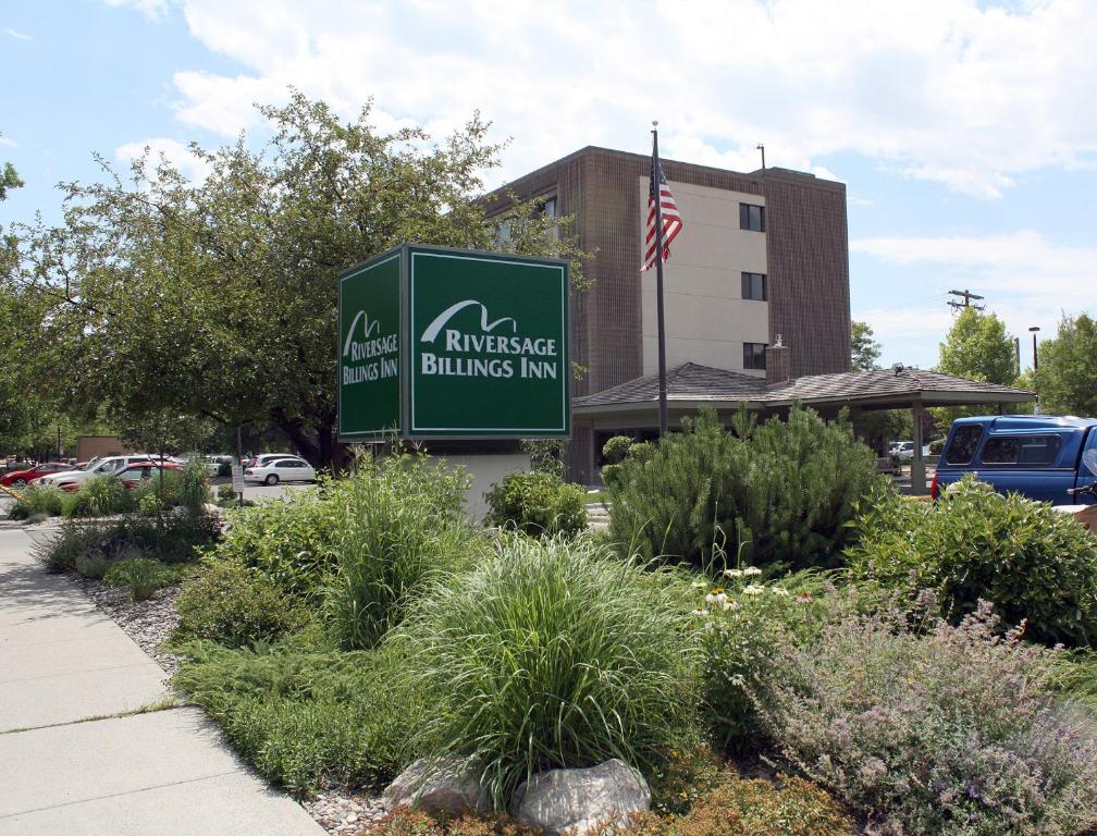 una señal para un edificio con bandera americana en Riversage Billings Inn, en Billings