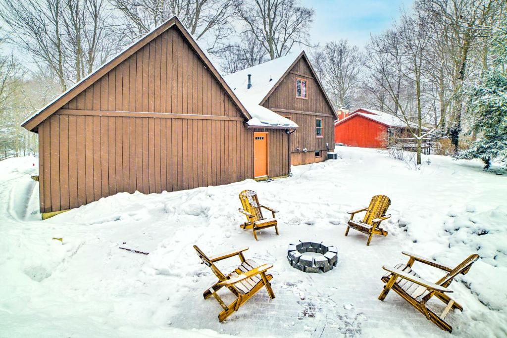 un grupo de bancos en la nieve frente a un granero en Holland Home with Fire Pit - Walk to Lake! en Holland