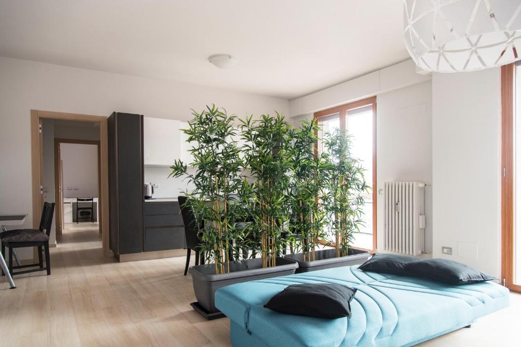 ein Schlafzimmer mit einem blauen Bett und Topfpflanzen in der Unterkunft YouHosty - Inganni 74 in Mailand