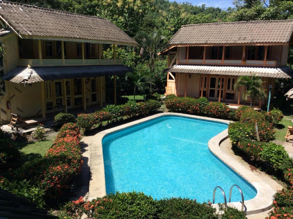 a swimming pool in front of a house at Villas de la Bahia Playa Tambor in Tambor