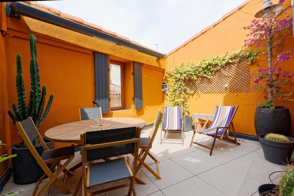 a patio with a wooden table and chairs at Air-conditioned duplex apartment with furnished terrace in the city center in Aix-en-Provence