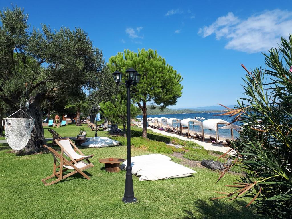 a lamp post in the grass next to a beach at Anna Karra Studios & Apartments in Vourvourou