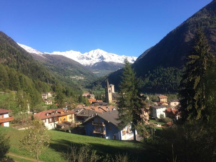 una pequeña ciudad en un valle con montañas cubiertas de nieve en Mansarda Trentino-Campiglio, en Ossana