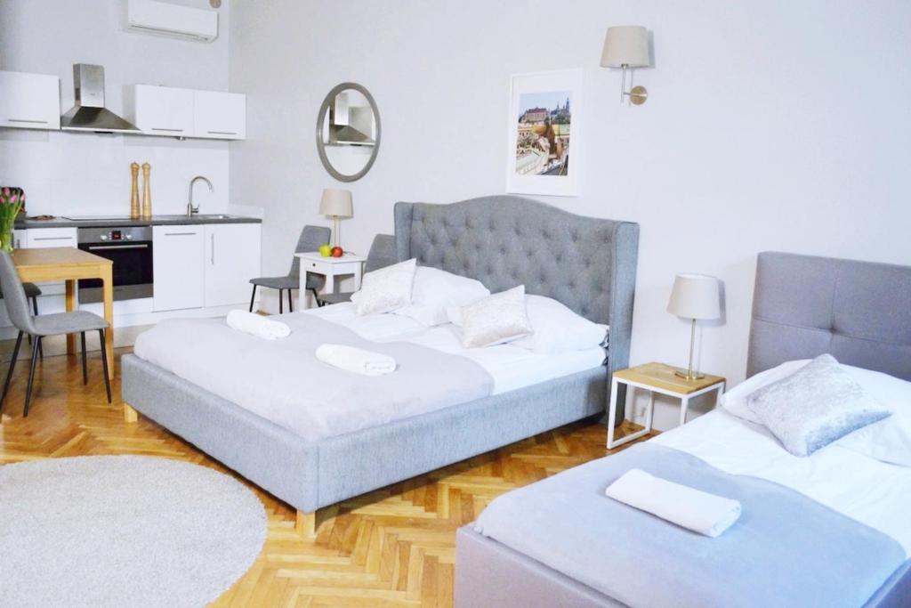 uma sala de estar com 2 camas e uma cozinha em 21 Floriańska Street Apartments em Cracóvia